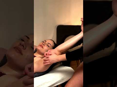 Watch as the therapist focuses on arm massage techniques, smoothing warm oil and tracing gentle circ