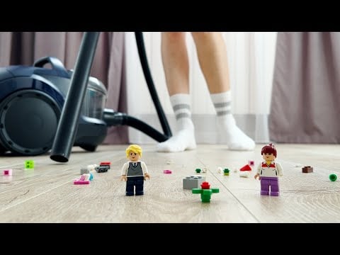 Cleaning the house with a vacuum cleaner of toys