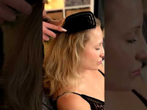 Watch as the therapist smooths warm oil into the client's hair, easing tension with practiced grace