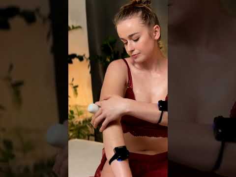 Dominique traces a white cream along her arm, its cool texture melting into her skin. Her hands find