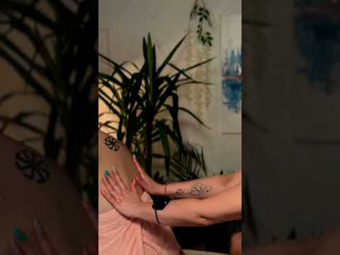 Watch as Mira focuses on back massage techniques, her teal and pink nails tracing gentle circles ove