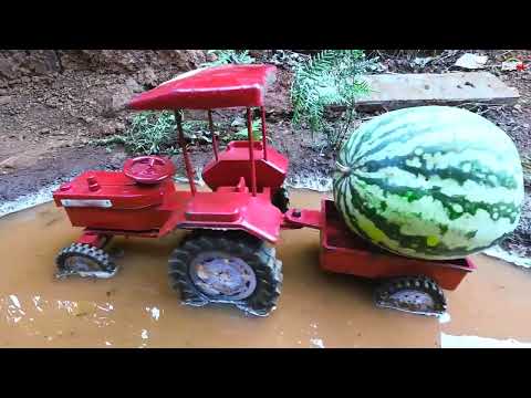 Mini Tractor stuck in mud with watermelon load helping mini John Deere tractor