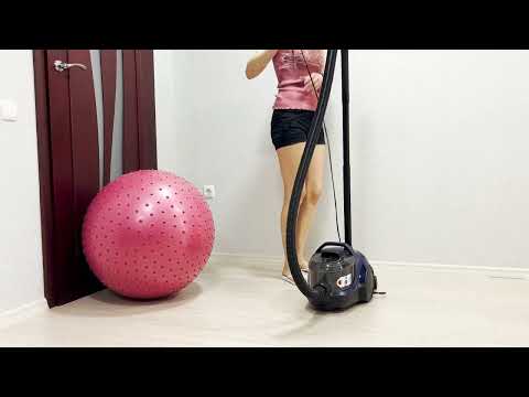 Fitness ball. A girl in shorts removes dust with a Bosch vacuum cleaner. clean with me