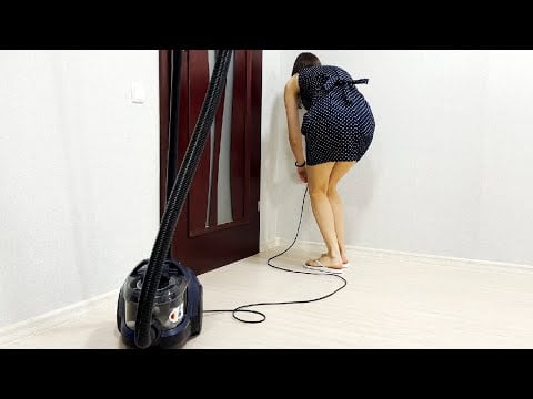 Experiment. Vacuum cleaner Bosch BGS21X320.Girl in a dress cleans the house